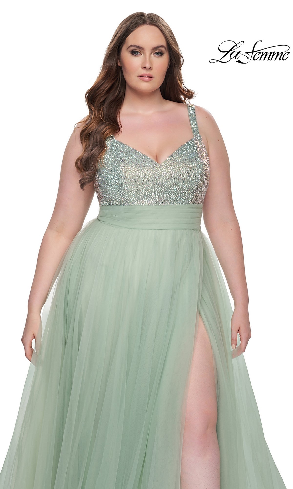 A woman wears the La Femme Long Prom Dress 31251, a plus-size mint green gown with a sparkly beaded bodice, tulle skirt, and high slit. The